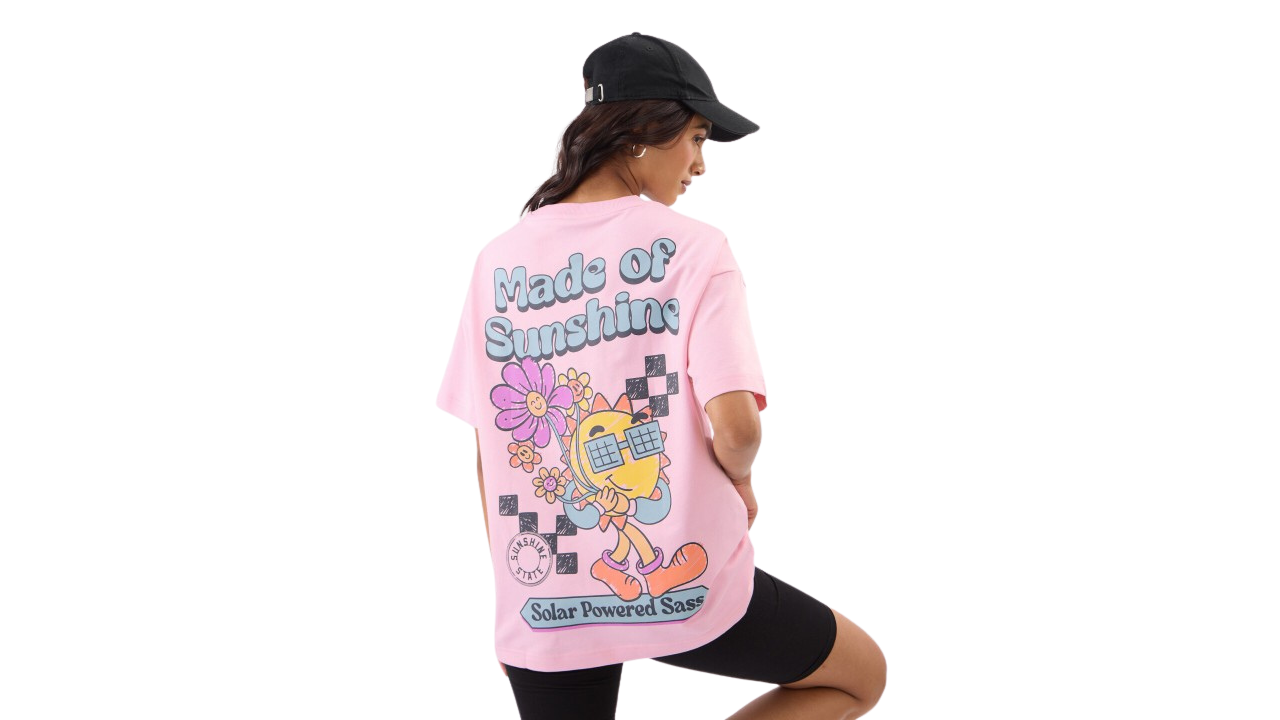 Pastel pink oversized t-shirt with a small smiling sun graphic on the front and "made of sunshine" text on the back.